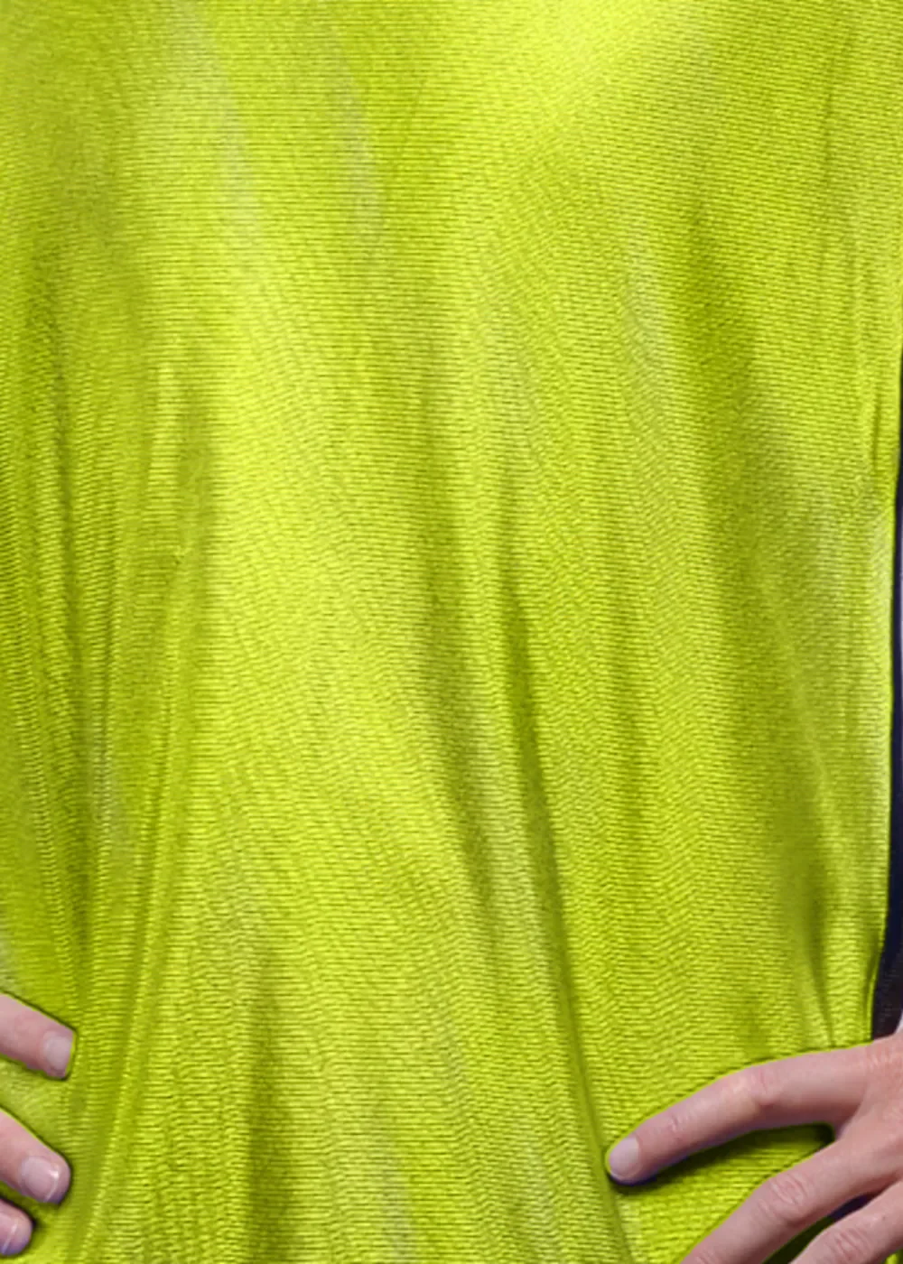 Close-up of the neon yellow vest: a smooth, silky polyester knit with a soft sheen and a bound, double-stitched black edge